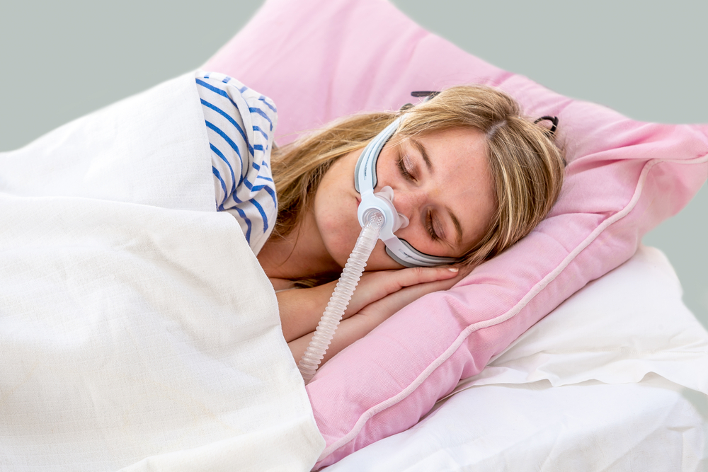 Woman asleep in bed with CPAP